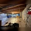 This crawl space shows damp floors and insulation in need of replacement.