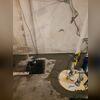 The sump pump collects water from the sub-floor drainage system and pumps it up and out of the basement through the white discharge lines.