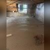 This crawl space experienced water issues, so drainage matting is being installed to manage groundwater.
