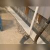 After fitting the WaterGuard subfloor drains in the trenches, we cover them in tape to make sure moisture stays away from the concrete we lay over it.