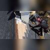 The crew properly installs shingles around the chimney before flashing installation