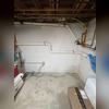 inished radon mitigation piping installed along the basement wall with sealed extraction point and clean vertical routing.