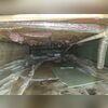 This crawl space shows damp floors and insulation in need of replacement.