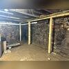 Damp stone walls were contributing to moisture issues throughout the historic basement.