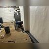 The WaterGuard system is carefully laid in place along the trench, ready to channel water away from the basement.