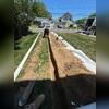 Trenches are carefully graded as the discharge line is laid, ensuring water will flow downhill without obstruction.