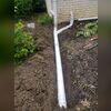 Our crew digs a trench outside to extend the sump pump downspout underground. This ensures water is pumped away from the foundation to prevent it from getting back into the crawl space.