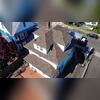 A clean drone shot captures the completed architectural asphalt roof, boasting immaculate ridge lines and brand-new metal flashing.