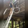 Crewman injecting RetroFoam insulation into the wood exterior walls of this home.