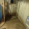 Inside of this basement, the concrete floor, as well as the foundation walls were stained, dark, and eroding from years of persistent moisture.