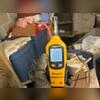 Checking humidity levels in the crawl space during inspection.