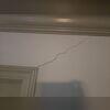 Cracking in the sheetrock above a doorway was one of the visible signs that the floor system below was settling. As floor joists sag, movement can transfer into the walls above and lead to cracks throughout the home.