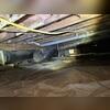This photo captures the crawl space before repairs began. The exposed floor joists and insulation show signs of long-term moisture exposure, while the aging vapor barrier is no longer providing complete protection. Excess humidity in a crawl space like this can contribute to musty odors, poor air...