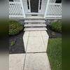 A closer look at the front walkway and porch before concrete repair, showing the areas needing attention.