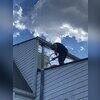 Crewman injection foam into exterior walls of home