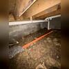 To manage water intrusion under the home, a drainage line was installed along the perimeter of the crawl space.