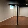 The crew painted the ceiling with black paint to hide ducts, joists, and wires and preserve as much overhead space as possible. They also relocated the sump pump and enclosed it in a corner closet.