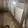 With the beams in place, the crew installs the WaterGuard drainage pipe and backfills the rest of the trench with clean gravel.