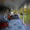 Lenore's refreshed covered porch in Cambridge Springs, PA, features premium TimberTech composite decking, colorful seating, and views of her backyard gardens and pool, a welcoming space to host friends and enjoy weekends without the annual painting chore.