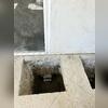 Concrete access openings beside the sliding door expose the foundation and installed push pier brackets. This view shows neighboring support locations during Saber's foundation repair work in Santa Ana, CA.