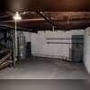 View of the unfinished basement before the radon mitigation system was installed, showing the open concrete floor and foundation walls.