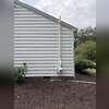 Completed exterior radon piping with the exhaust extending above the roofline to vent radon outdoors.